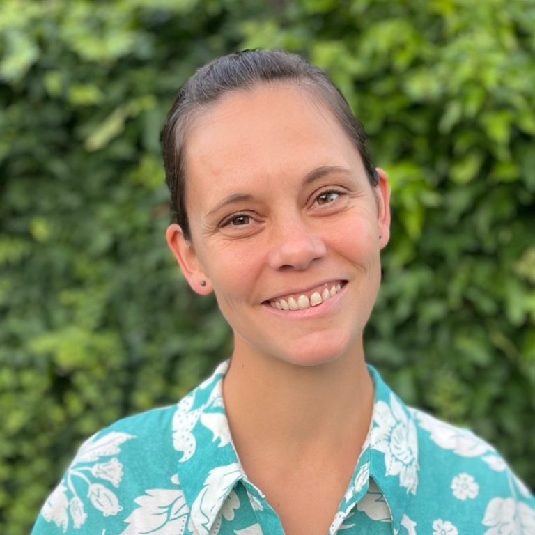 Tagesmutter Marika Wilcke-Fischer Frau mit einem freundlichen Lächeln, trägt ein blaues Hemd mit weißen Blumenmotiven.