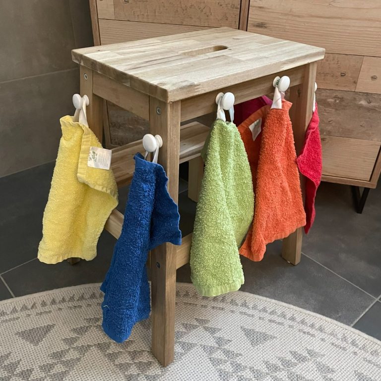 Kindertagespflege Rodenbach - unsere Einrichtung Ein Holzstuhl mit bunten Handtüchern in orange, grün, blau und gelb.